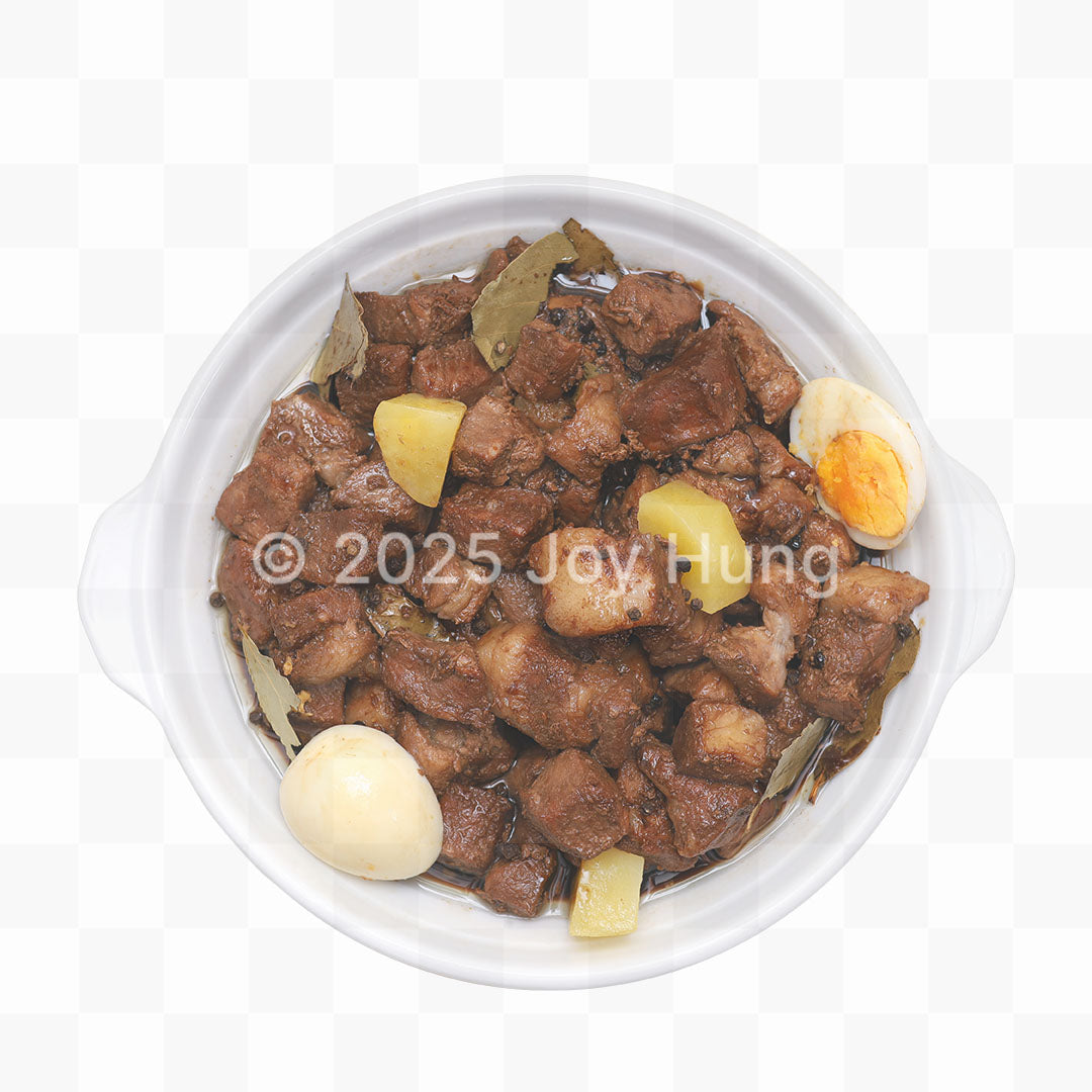 Stewed meat dish with potatoes and eggs in a white bowl on a white background