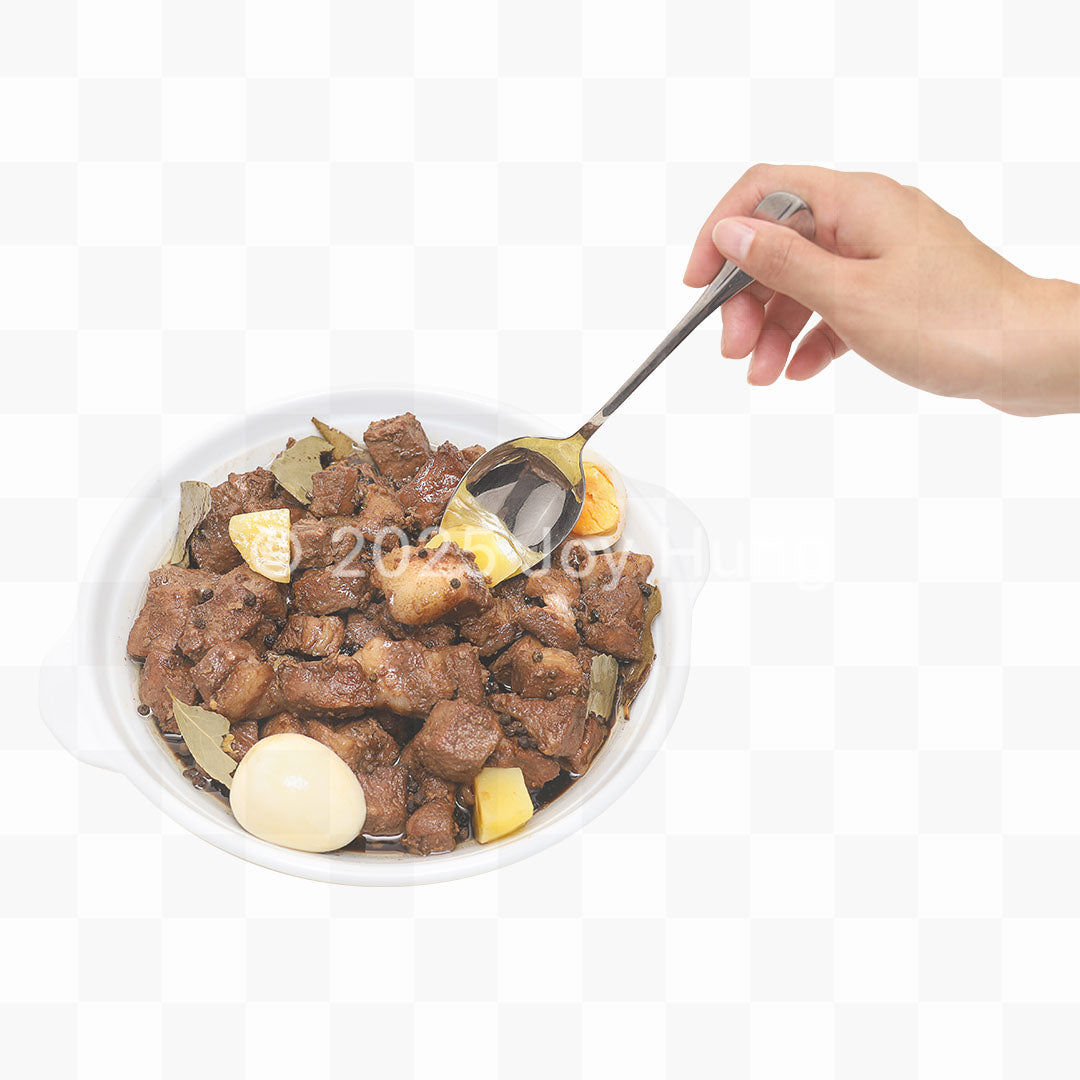 Hand holding a spoon over a bowl of food on a white background