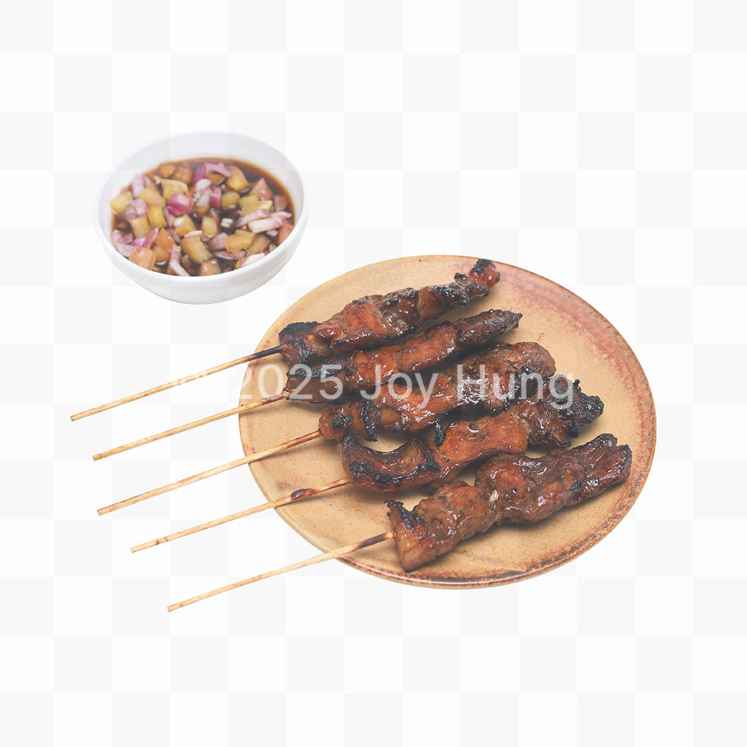 Skewered meat on a wooden plate with a small bowl of sauce on a white background