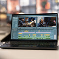 Laptop displaying video editing software with a blurred background